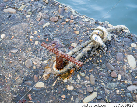 Place for attaching a small boat. Fittings for tying the mooring line. Mounting point. Small bollard on the pier. Place for attaching a small boat. Fittings for tying the mooring line. Mounting point. Small bollard on the pier. 137166928