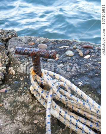 Place for attaching a small boat. Fittings for tying the mooring line. Mounting point. Small bollard on the pier. Place for attaching a small boat. Fittings for tying the mooring line. Mounting point. Small bollard on the pier. 137166931
