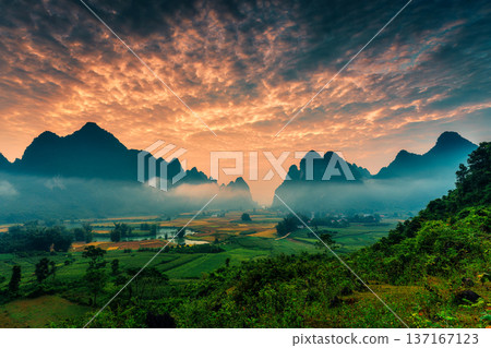 Landscape of vibrant sunrise over mountain range with foggy, river and traditional village in Phong Nam Valley 137167123