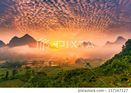 Landscape of vibrant sunrise over mountain range with foggy, river and traditional village in Phong Nam Valley Landscape of vibrant sunrise over mountain range with foggy, river and traditional village in Phong Nam Valley 137167127