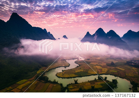 Dramatic sunrise over mountain range with foggy on rural village and river flows through in Phong Nam Valley at Cao Bang, Vietnam Dramatic sunrise over mountain range with foggy on rural village and river flows through in Phong Nam Valley at Cao Bang, Vietnam 137167132