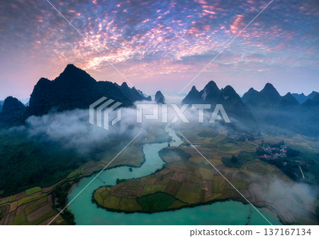 Sunrise over mountain range with foggy on rural village and river flows through in Phong Nam Valley at Vietnam Sunrise over mountain range with foggy on rural village and river flows through in Phong Nam Valley at Vietnam 137167134