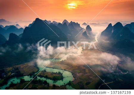 Sunrise over mountain range with foggy on rural village and river flows through in Phong Nam Valley at Vietnam Sunrise over mountain range with foggy on rural village and river flows through in Phong Nam Valley at Vietnam 137167139