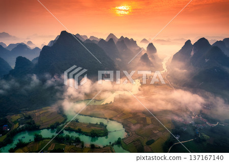 Sunrise over mountain range with foggy on rural village and river flows through in Phong Nam Valley at Vietnam Sunrise over mountain range with foggy on rural village and river flows through in Phong Nam Valley at Vietnam 137167140