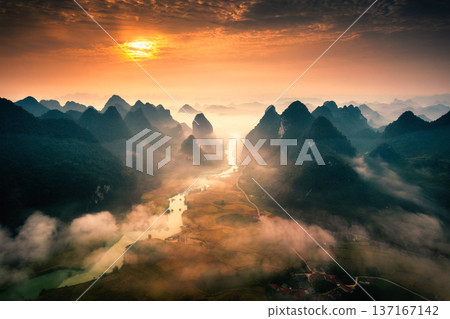 Sunrise over mountain range with foggy on rural village and river flows through in Phong Nam Valley at Vietnam Sunrise over mountain range with foggy on rural village and river flows through in Phong Nam Valley at Vietnam 137167142