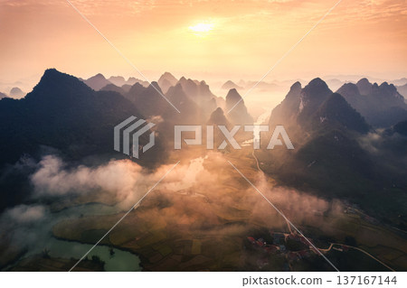 Golden sunrise over mountain range with foggy on rural village and river flows through in Phong Nam Valley at Cao Bang, Vietnam Golden sunrise over mountain range with foggy on rural village and river flows through in Phong Nam Valley at Cao Bang, Vietnam 137167144