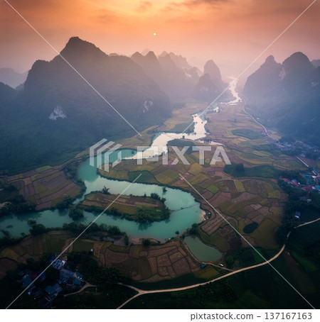 Sunrise over mountain range with foggy on rural village and river flows through in Phong Nam Valley at Vietnam Sunrise over mountain range with foggy on rural village and river flows through in Phong Nam Valley at Vietnam 137167163