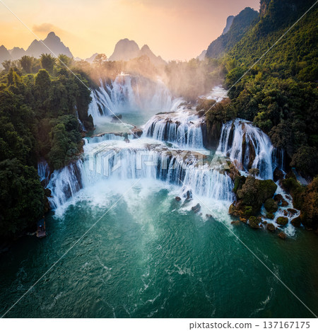 Majestic Ban Gioc waterfall, Detian Falls flowing in tropical forest during the sunset at Cao Bang, Vietnam 137167175