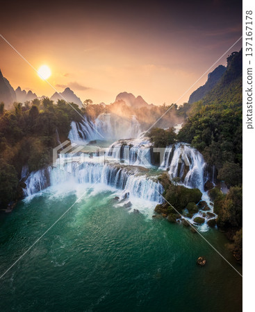 Majestic Ban Gioc waterfall, Detian Falls flowing in tropical forest during the sunset at Cao Bang, Vietnam 137167178