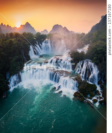 Majestic Ban Gioc waterfall, Detian Falls flowing in tropical forest during the sunset at Cao Bang, Vietnam 137167180