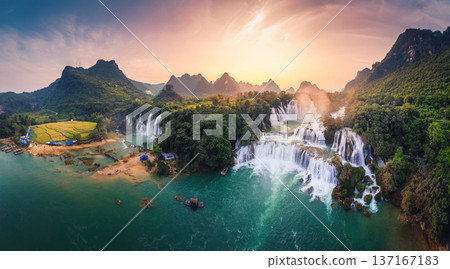 Majestic Ban Gioc waterfall, Detian Falls flowing in tropical forest during the sunset at Vietnam Majestic Ban Gioc waterfall, Detian Falls flowing in tropical forest during the sunset at Vietnam 137167183