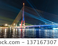 Colorful night view of suspension bridge with light up reflection on waterfront 137167307