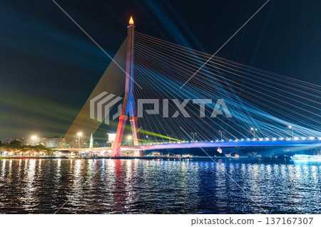 Colorful night view of suspension bridge with light up reflection on waterfront 137167307