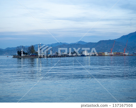 Port area on the Black Sea in winter. Sea cityscape at dusk. Batumi seaport. Industrial zone. 137167508