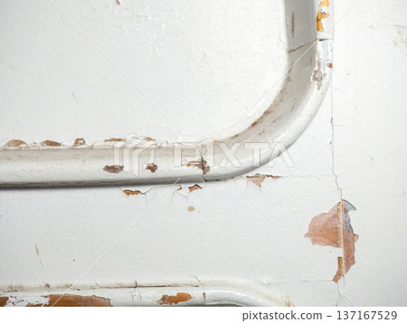 Part of an old door. White paint is coming off the wood. Surface with peeling paint. Part of an old door. White paint is coming off the wood. Surface with peeling paint. 137167529