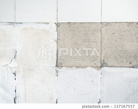 background of broken white tiles. The wall needs repairs. The concept of ruin and abandonment. Chipped tile. background of broken white tiles. The wall needs repairs. The concept of ruin and abandonment. Chipped tile. 137167557