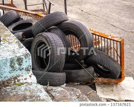 pile of dumped used car tires. Lots of rubber. Tire dump. Industrial zone. Next to the auto repair shop. pile of dumped used car tires. Lots of rubber. Tire dump. Industrial zone. Next to the auto repair shop. 137167621