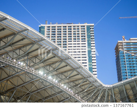 vault of a modern football stadium. Canopy of the sports arena. Metal construction. Stadium concept. Construction site nearby. vault of a modern football stadium. Canopy of the sports arena. Metal construction. Stadium concept. Construction site nearby. 137167761