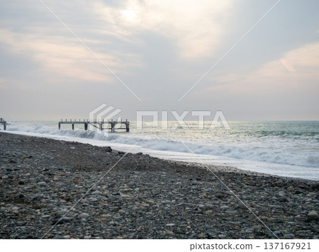 Destroyed pier under the waves. Bad weather at sea. Beautiful seashore with old architecture Destroyed pier under the waves. Bad weather at sea. Beautiful seashore with old architecture 137167921
