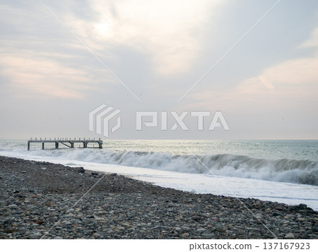 Destroyed pier under the waves. Bad weather at sea. Beautiful seashore with old architecture. Destroyed pier under the waves. Bad weather at sea. Beautiful seashore with old architecture. 137167923