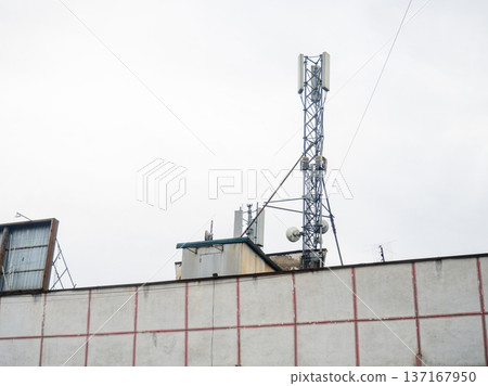 Cell phone tower on the roof of a building. The concept of abundant internet. Antenna for cell phone communication. Cell phone tower on the roof of a building. The concept of abundant internet. Antenna for cell phone communication. 137167950