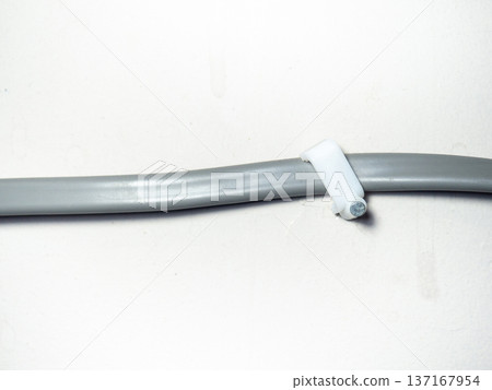 Fastening the wire to the wall. Ceiling mounting. Electric cord in the apartment. 220 volt. Fastening the wire to the wall. Ceiling mounting. Electric cord in the apartment. 220 volt. 137167954