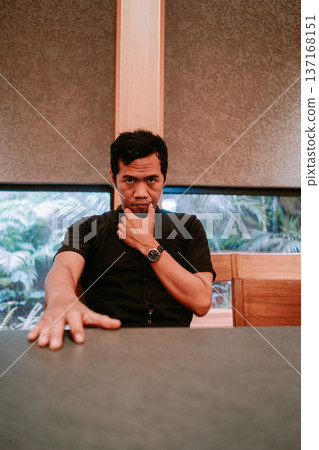 Pensive Young Man Looking Directly at Camera 137168151