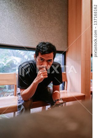 Thoughtful Man Looking Directly at Camera in Indoor Setting Thoughtful Man Looking Directly at Camera in Indoor Setting 137168162