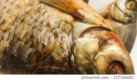 Two dry fish on a white sheet of paper. 137168882