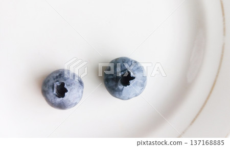 Two blueberries on a plate. Two blueberries on a plate. 137168885