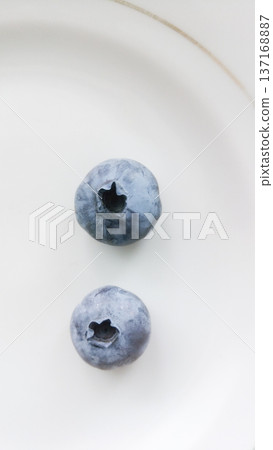 Two blueberries on a plate. Two blueberries on a plate. 137168887
