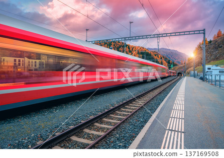 Blurred red passenger train passing mountain railway station 137169508
