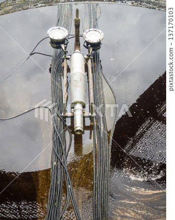 Empty fountain in a city park. Dehumidification. Cleaning the fountain with a hose. The device of the fountain. Pipes for water supply. Water hoses. Modern technologies. 137170103
