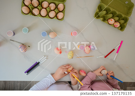 Top View of Children Drawing on Easter Eggs, Hands Only 137170135