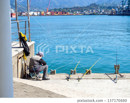 Fishermen in the port of Batumi. Waiting for a peck. People on vacation. Hobbies for people. Day off at the port. Fish catchers Fishermen in the port of Batumi. Waiting for a peck. People on vacation. Hobbies for people. Day off at the port. Fish catchers 137170880