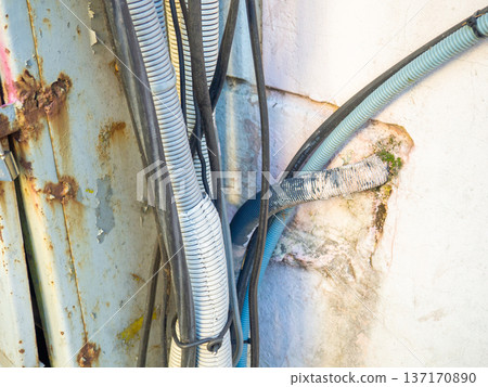 Electrical wiring on the wall outside. Sheathed wires. Energy supply for houses. Electrification. Modern technologies. Electrical wiring on the wall outside. Sheathed wires. Energy supply for houses. Electrification. Modern technologies. 137170890