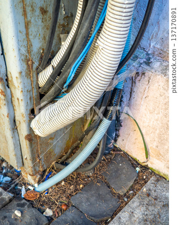 Electrical wiring on the wall outside. Sheathed wires. Energy supply for houses. Electrification. Modern technologies. Vintage. Electrical wiring on the wall outside. Sheathed wires. Energy supply for houses. Electrification. Modern technologies. Vintage. 137170891