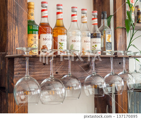 Glasses hang over the bar counter. The glasses are turned upside down. restaurant interior. Concept of drinking alcoholic beverages. Glass glasses for wine. Night club in daylight 137170895