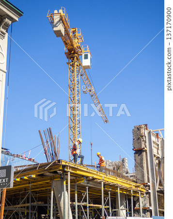 Builders on the roof of a house under construction. Construction industry. Workers at work. Construction of a new house Builders on the roof of a house under construction. Construction industry. Workers at work. Construction of a new house 137170900