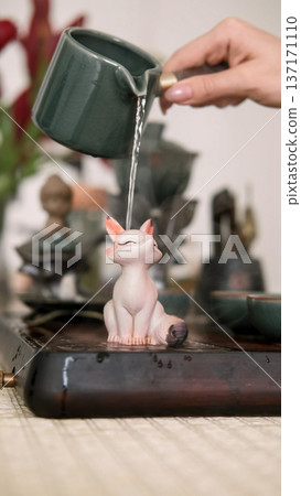 Pouring herbal drink. Chinese tea ceremony. Table with tea-board woman hand water vapor incense cup for drinking figurine changing color. Pouring herbal drink. Chinese tea ceremony. Table with tea-board woman hand water vapor incense cup for drinking figurine changing color. 137171110