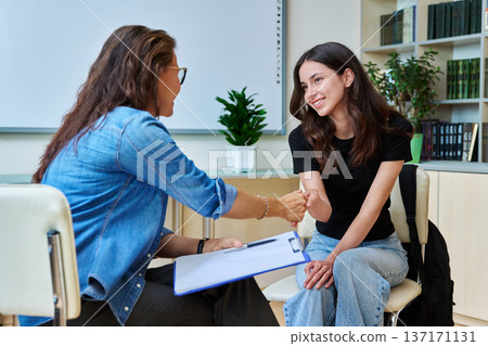 Teenage student girl with school counselor, coach in meeting room 137171131