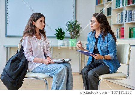 Female teacher, counselor working with school student teenage girl Female teacher, counselor working with school student teenage girl 137171132