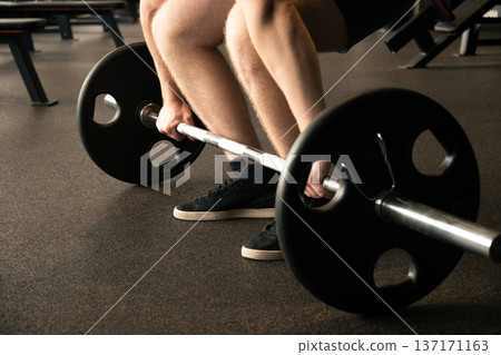 Man lifting barbell from floor deadlift preparation Man lifting barbell from floor deadlift preparation 137171163