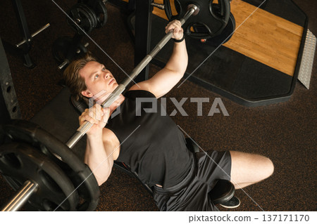 Man performing incline bench press with barbell Man performing incline bench press with barbell 137171170