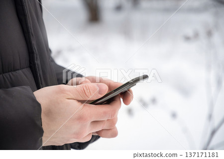 Person using smartphone outdoors in winter 137171181