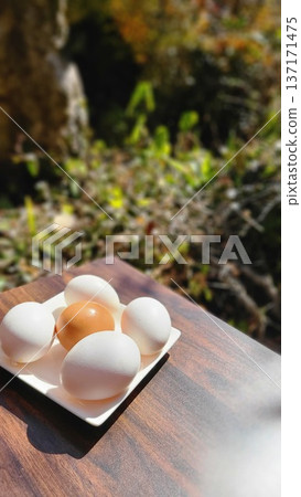 Four white eggs and one red egg on a plate Four white eggs and one red egg on a plate 137171475