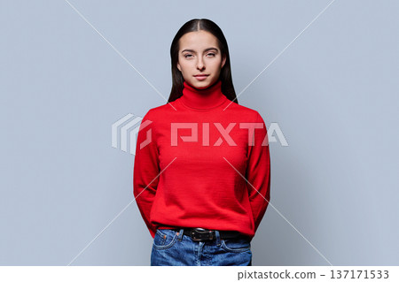 Portrait of beautiful serious teenage girl in red sweater on gray background Portrait of beautiful serious teenage girl in red sweater on gray background 137171533
