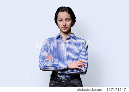 Portrait of serious young confident girl looking at camera on white background 137171547