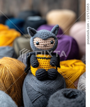 A cute crochet Batman character perched on a yarn gargoyle. Gotham city in the background made of dark knitted fabrics and felt. 137172053