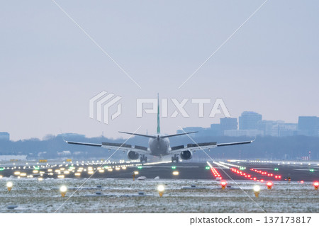 Passenger plane slowing down on airport landing strip with spoilers deployed in winter Passenger plane slowing down on airport landing strip with spoilers deployed in winter 137173817